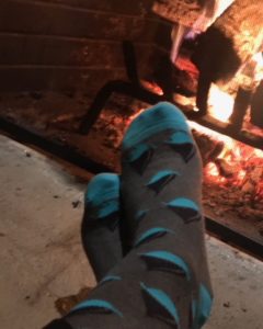 gray and blue Transparensa Fuels socks near fireplace